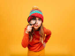Joyful Young Girl In Sweater And Hat Looking At Camera